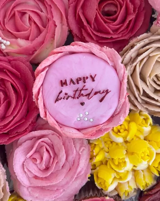 Mafin s natpisom „Happy birthday“ okružen ružama od kreme